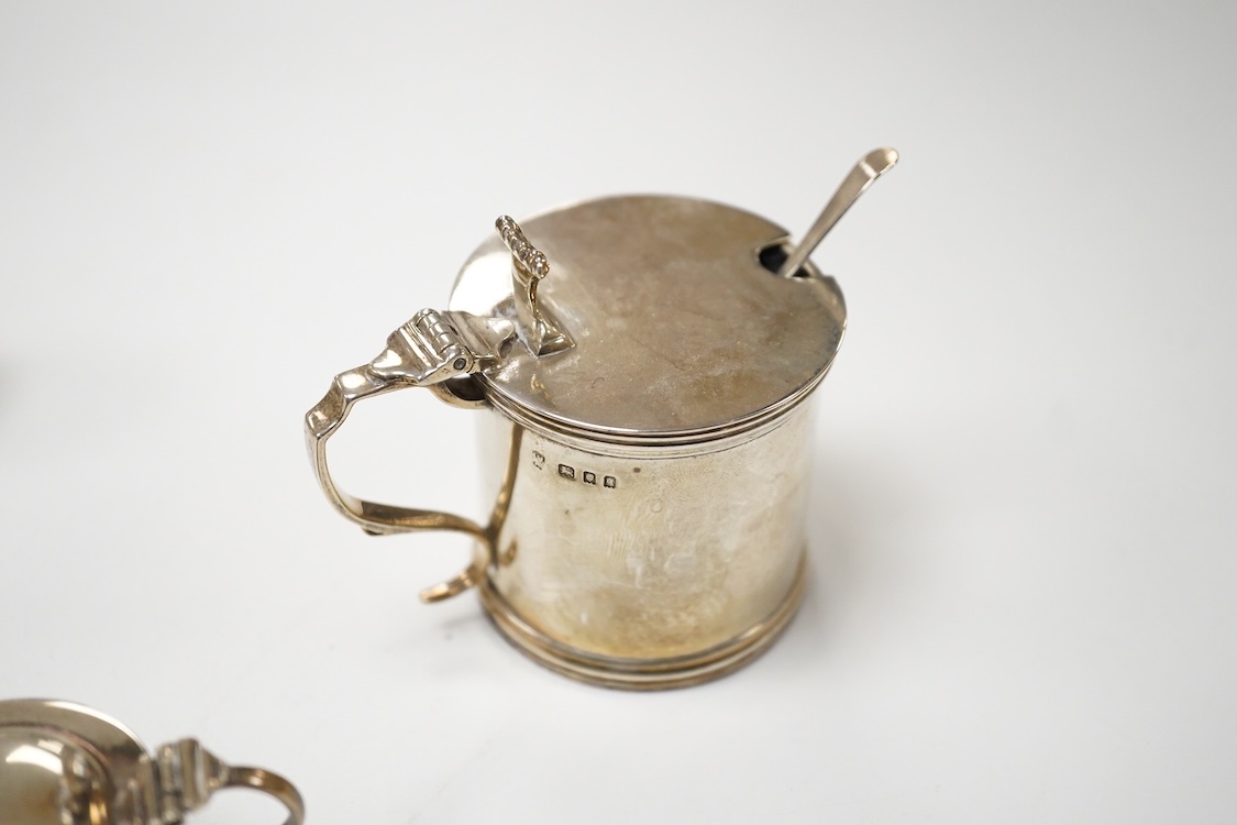 A George V silver mustard pot, London, 1931, with blue glass liner and associated silver shovel, together with a George V silver pepperette, a pair of small silver mustard pots and spoons, a pair of small silver pepperet